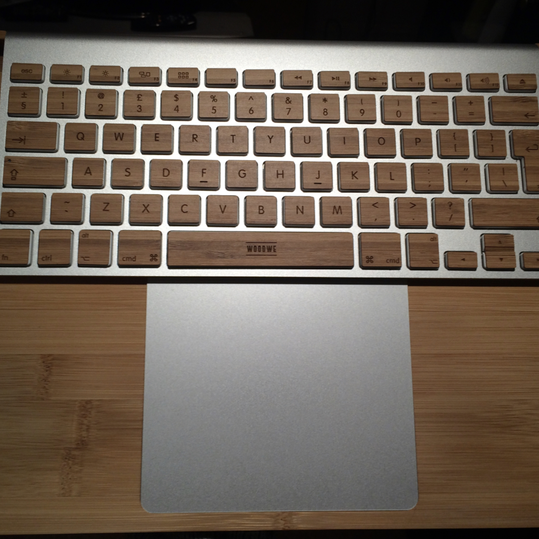 Apple keyboard and trackpad in laptop arrangement, housed in bamboo casing for ergonomic benefit